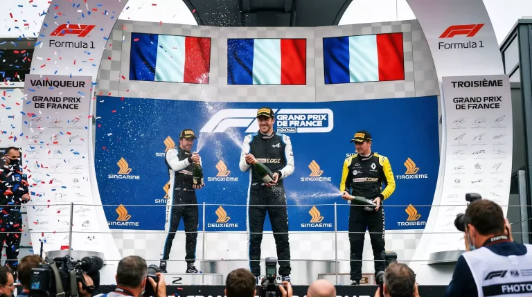 Podium de Grand Prix F1 avec trois pilotes et trophees de course